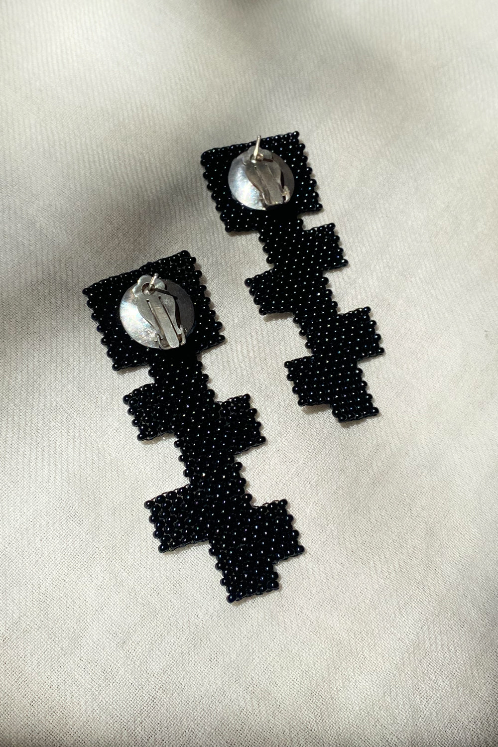 black glass beaded geometric cross earrings