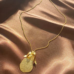 gold etched pear necklace on a dainty chain