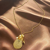 gold etched pear necklace on a dainty chain