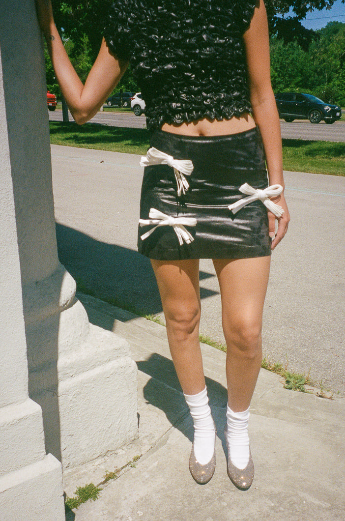 glossy black mini skirt with white bows