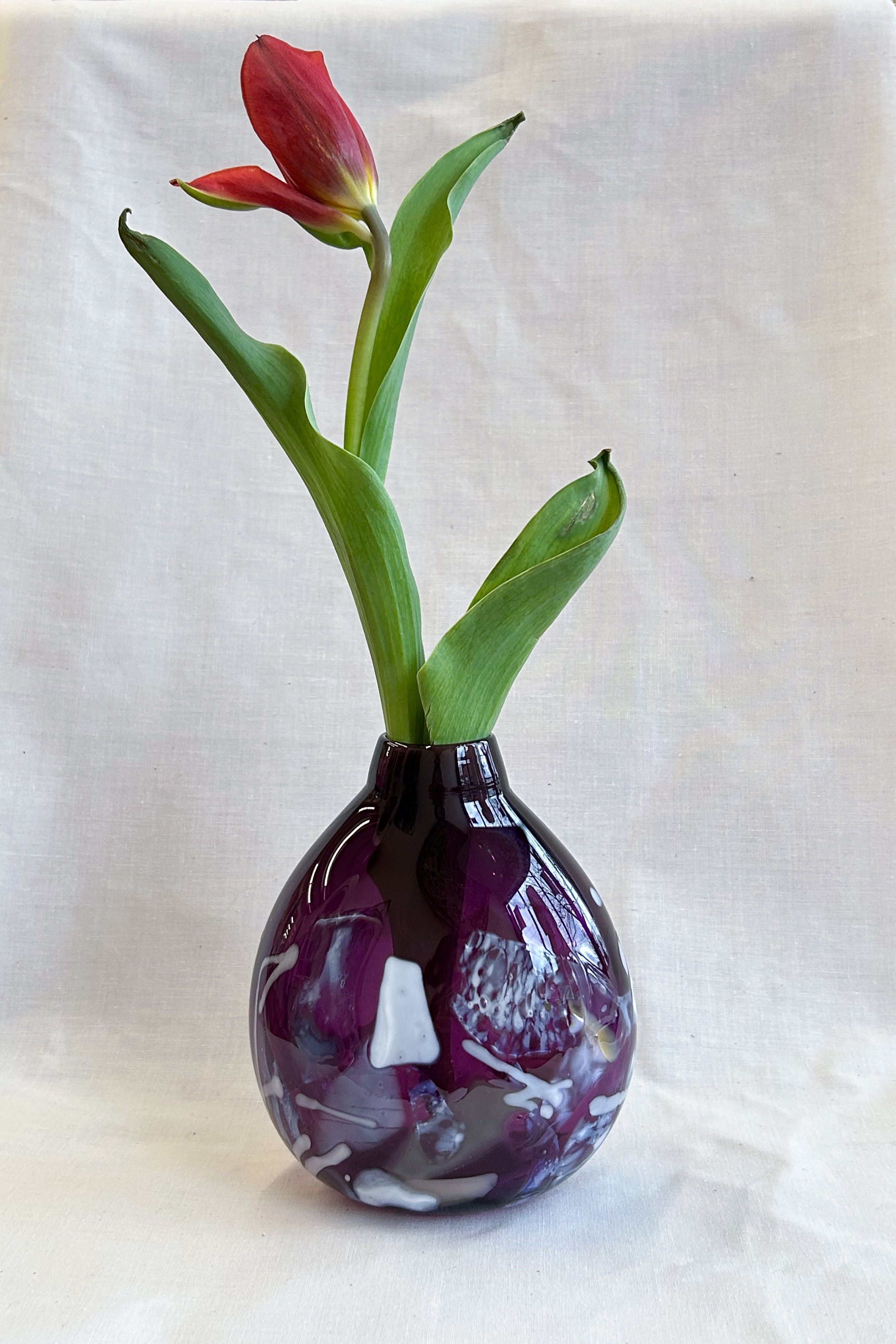 purple handblown glass vase with white patterns