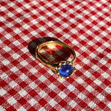 brass prong set ring with blue glass stone