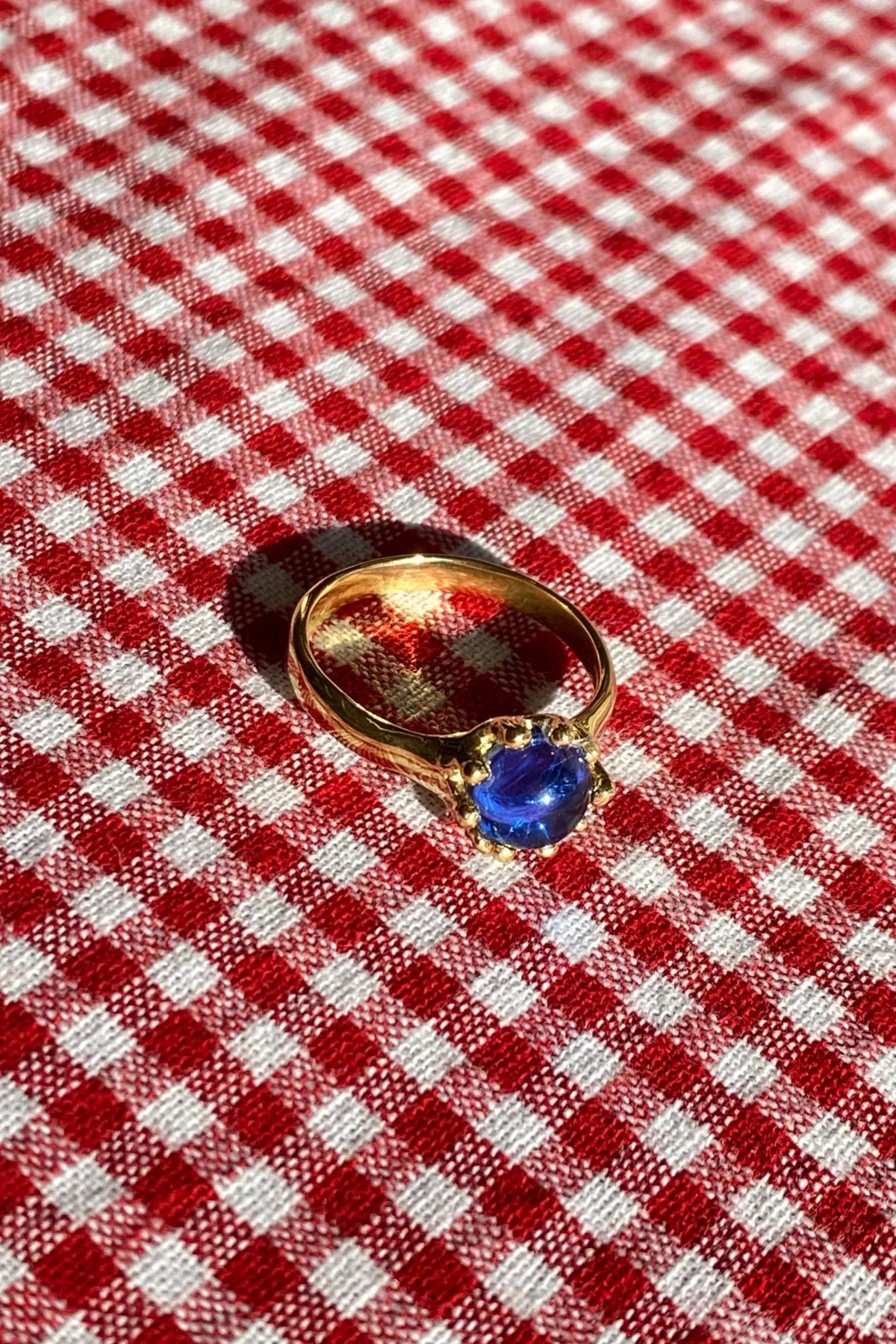 brass prong set ring with blue glass stone