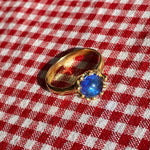 brass prong set ring with blue glass stone
