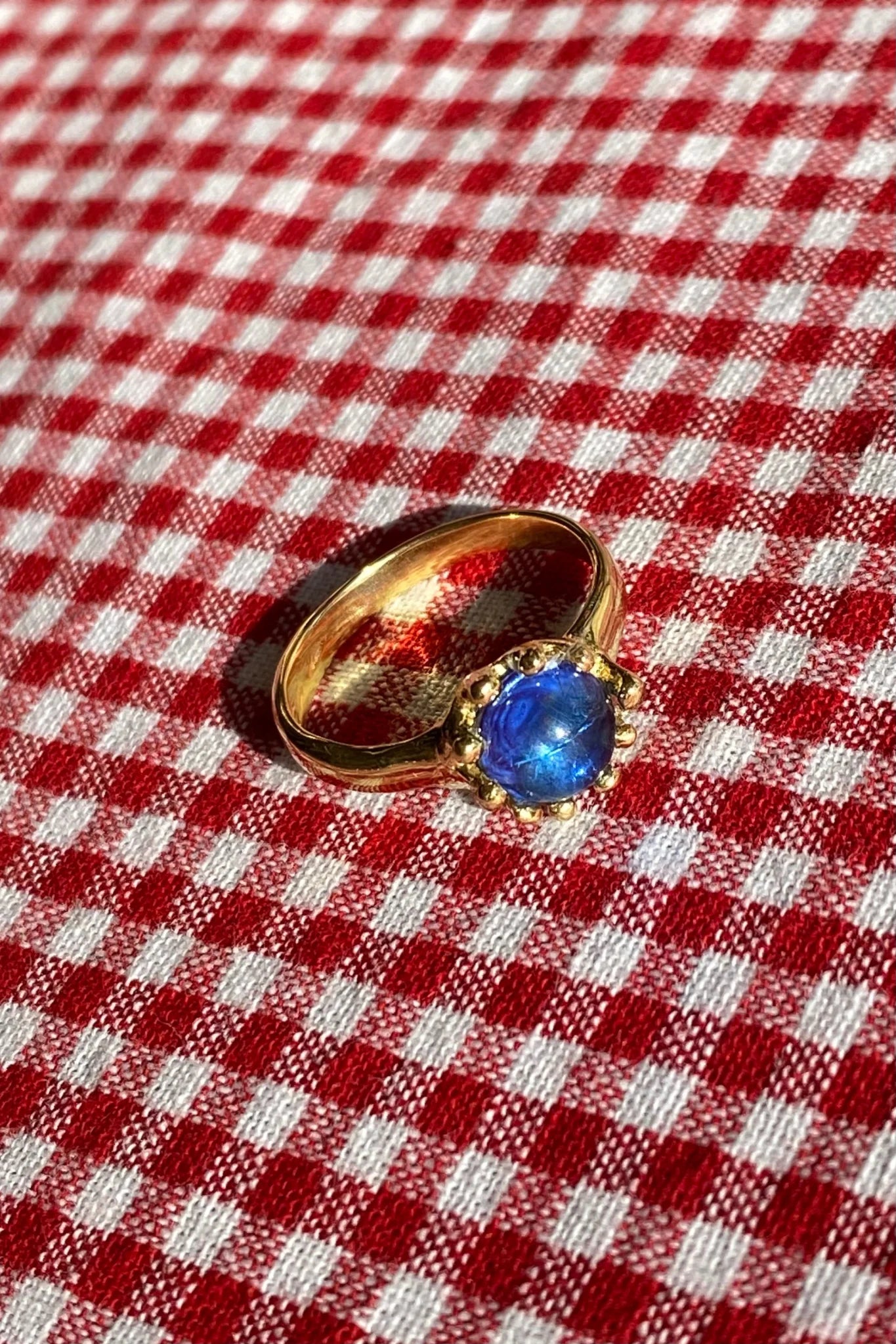 brass prong set ring with blue glass stone