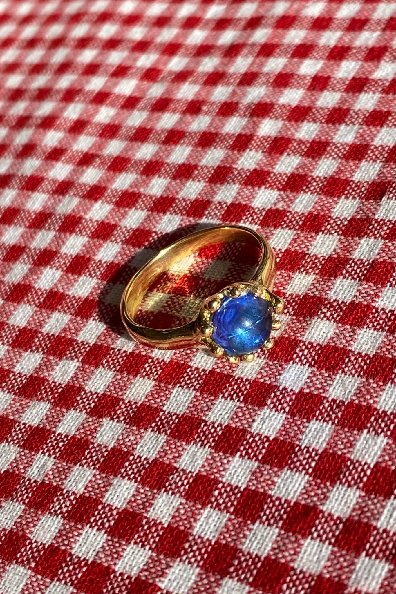 brass prong set ring with blue glass stone
