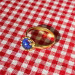 brass prong set ring with blue glass stone
