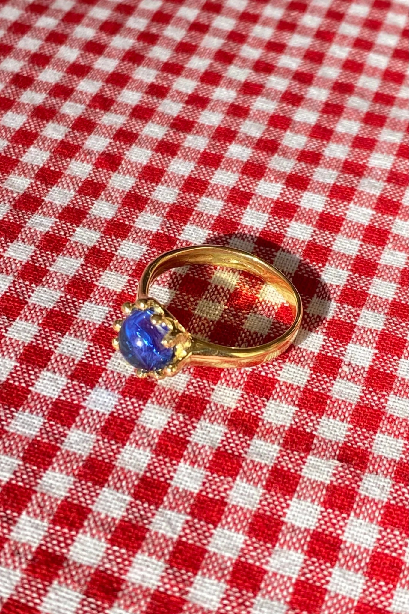 brass prong set ring with blue glass stone