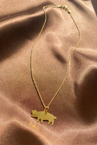 dainty gold pig pendant on a thin chain