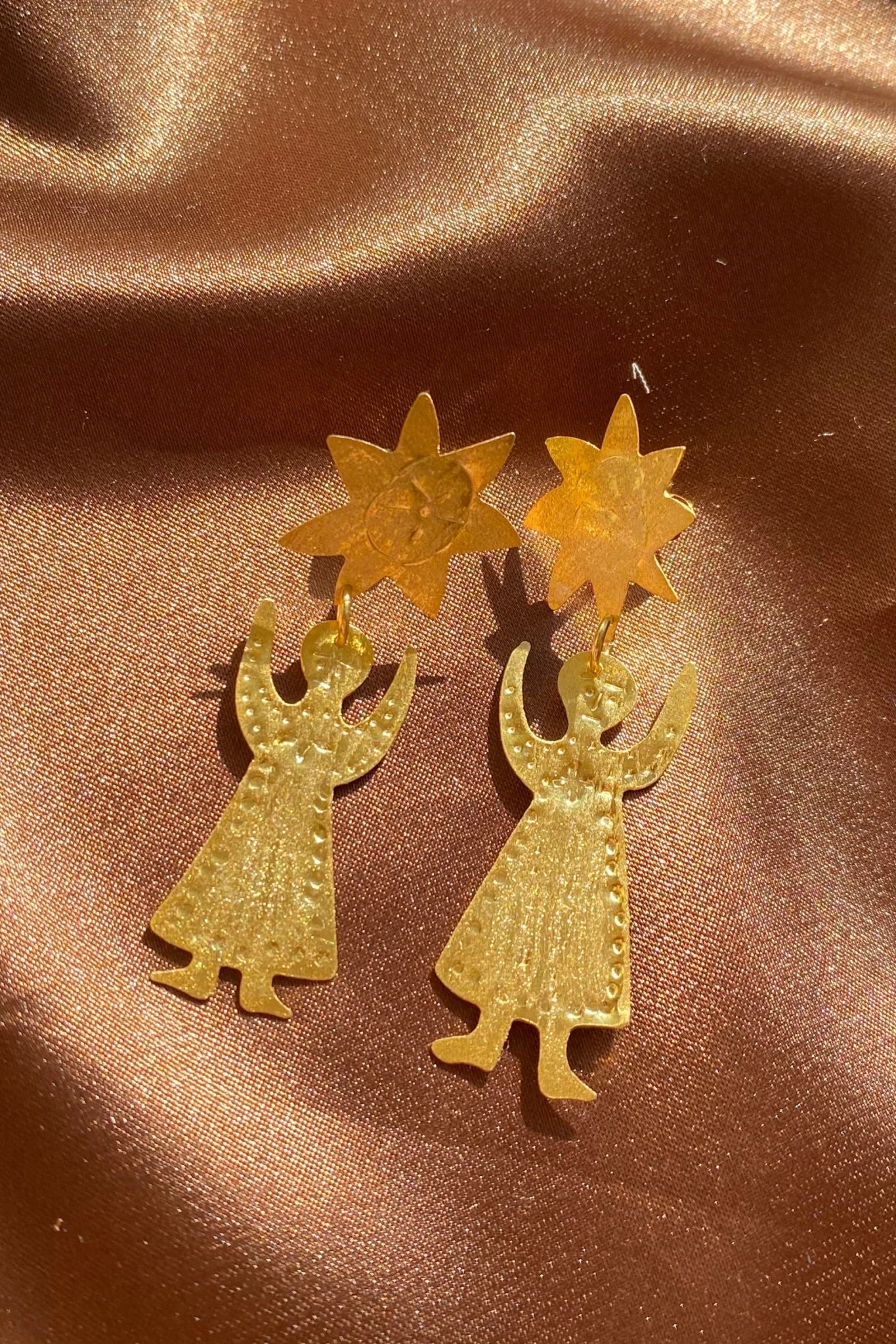 figures reaching to the sun gold etched earrings