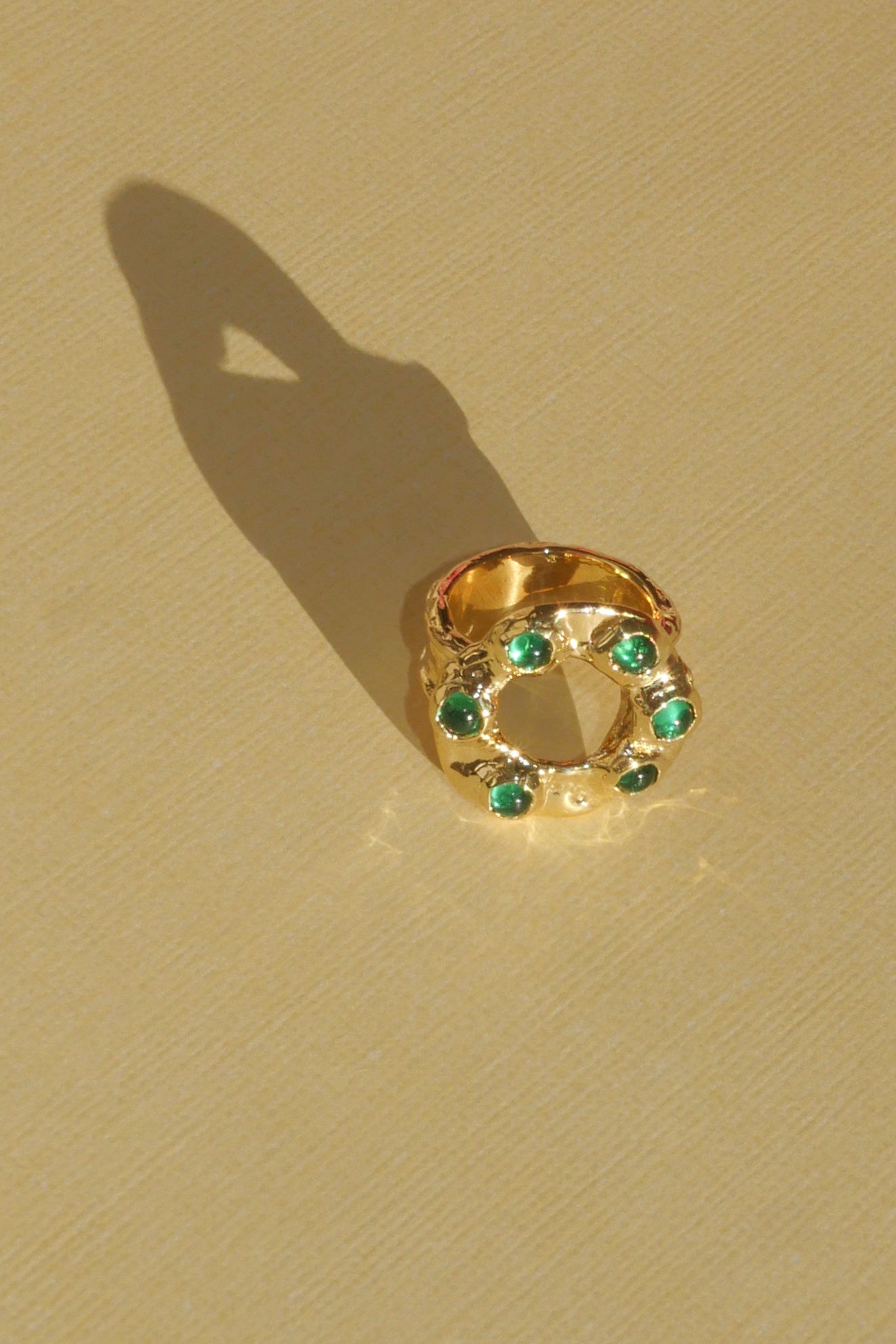 brass textured band ring with green stoned halo