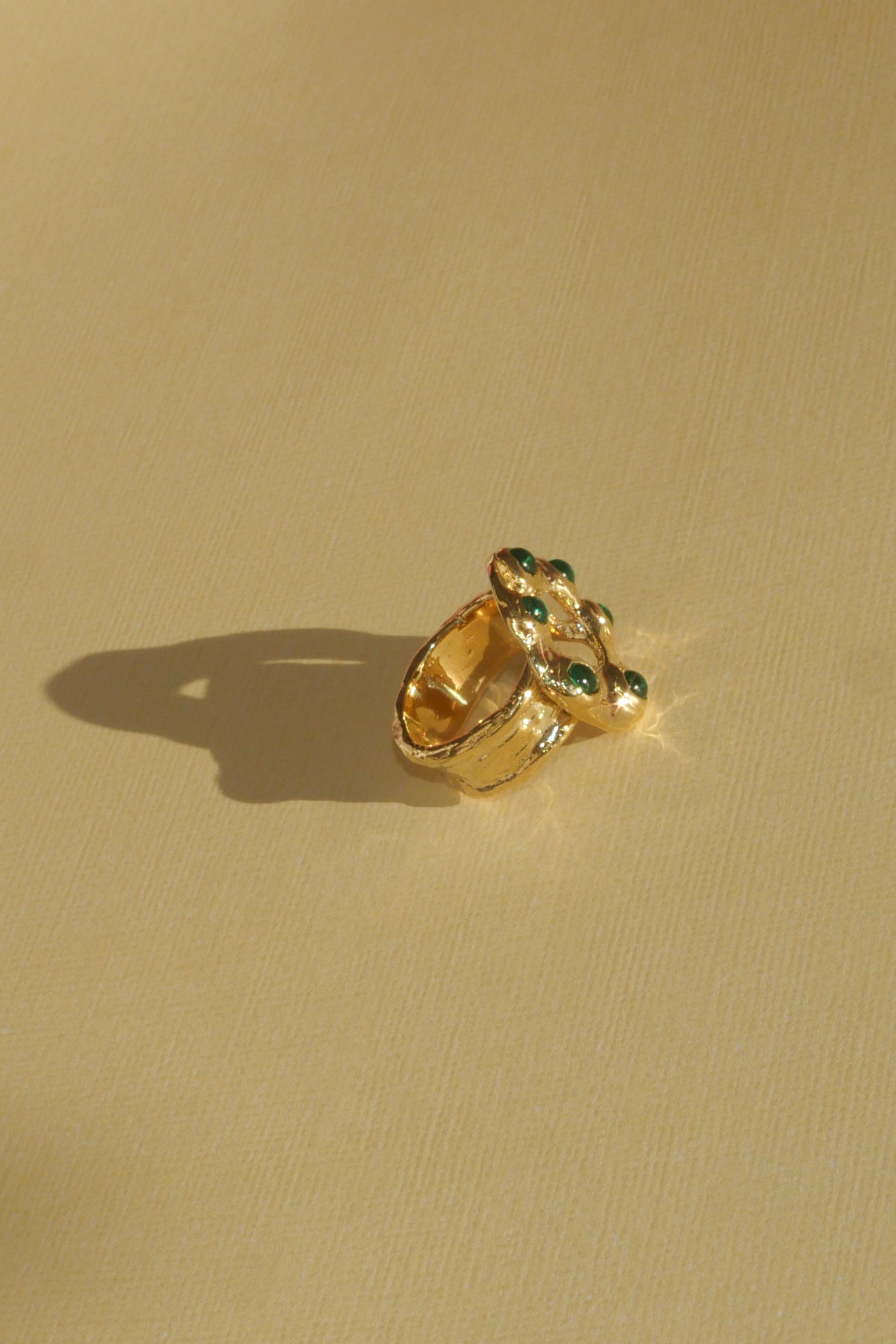brass textured band ring with green stoned halo