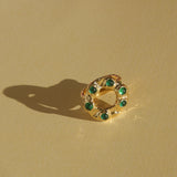 brass textured band ring with green stoned halo