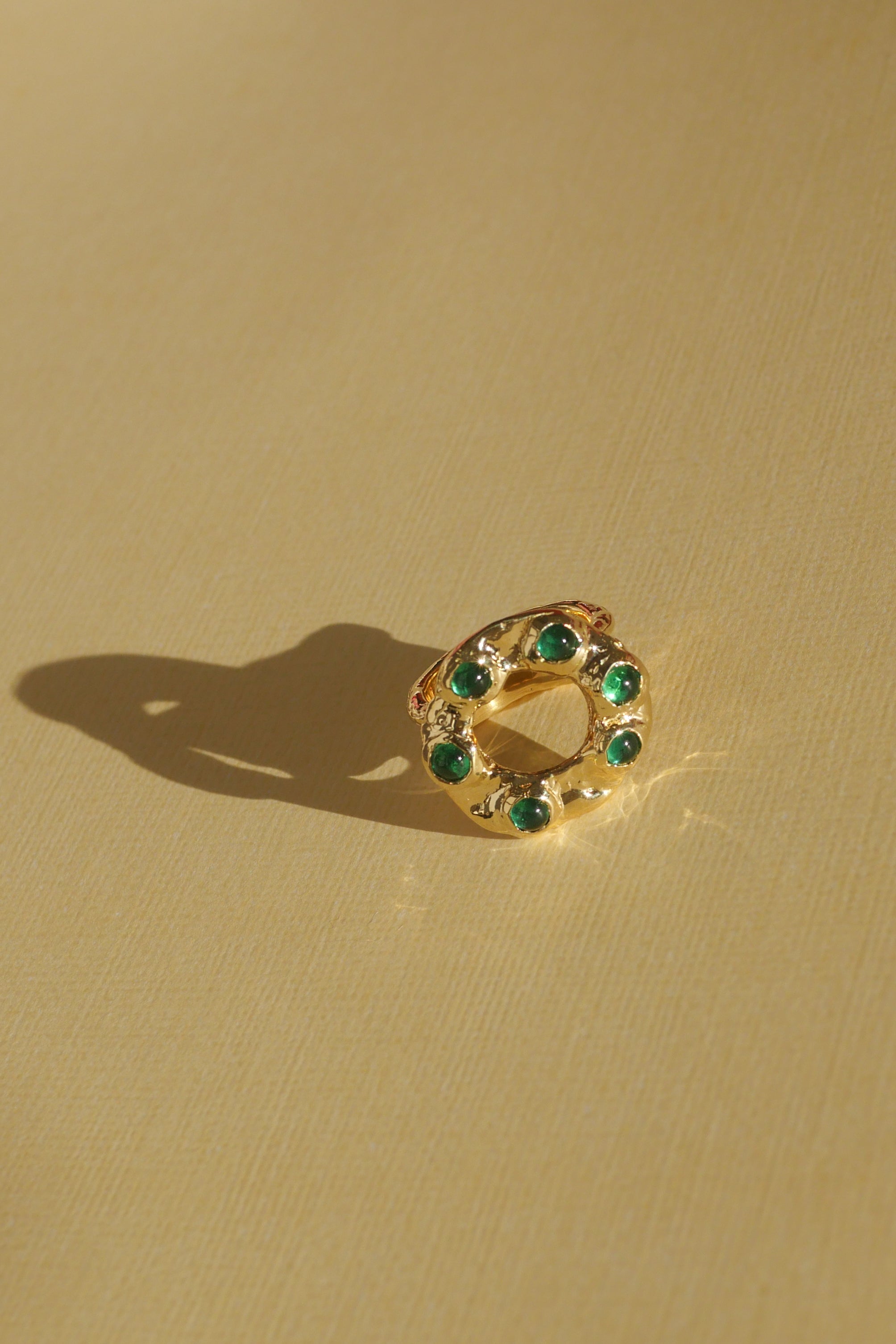 brass textured band ring with green stoned halo