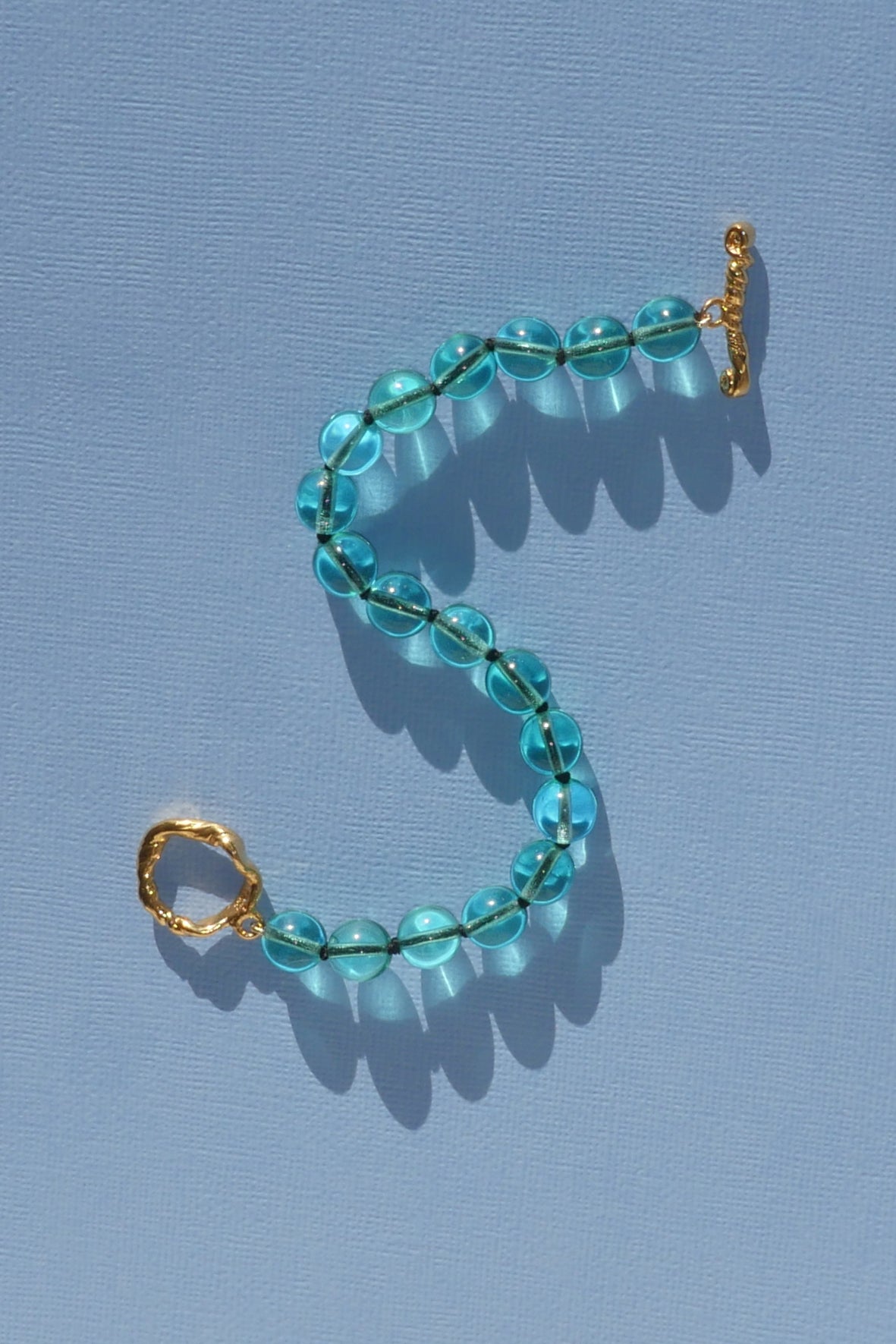 teal glass bead bracelet strung on silk thread