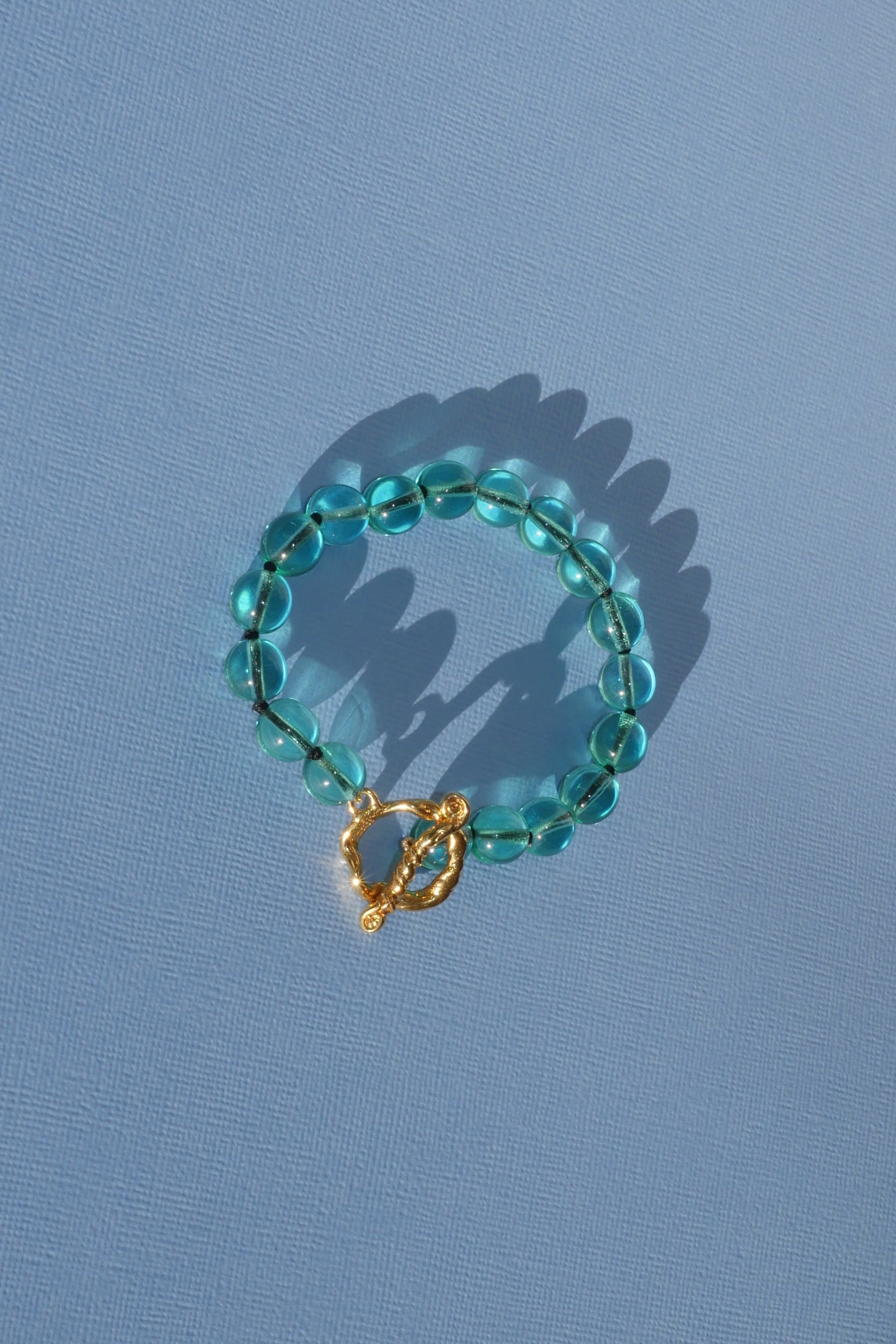 teal glass bead bracelet strung on silk thread